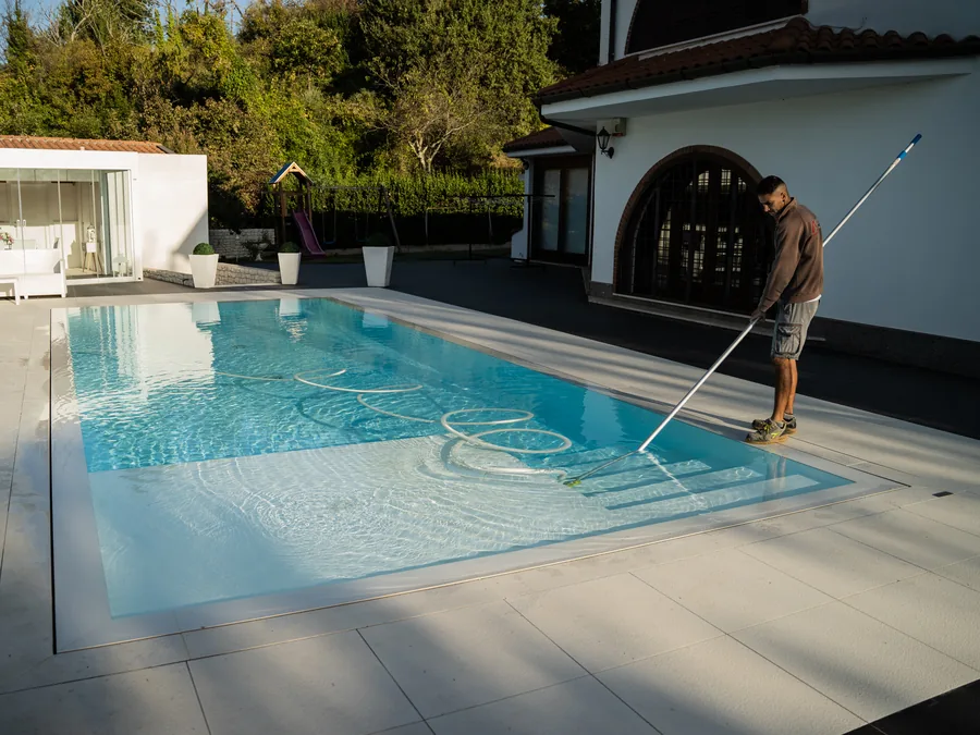 Tecnico al lavoro a bordo vasca di una piscina privata a Latina