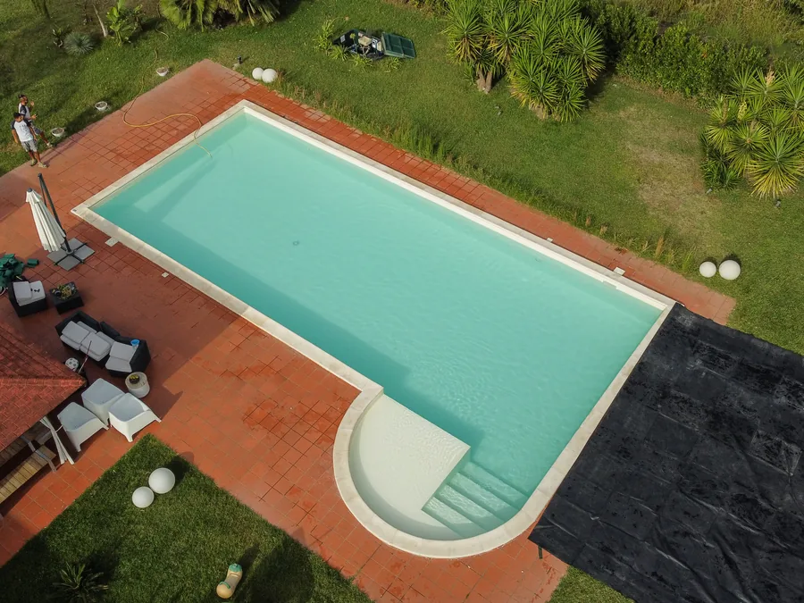 Vista dall&rsquo;alto di una piscina con solarium in un giardino privato a Latina